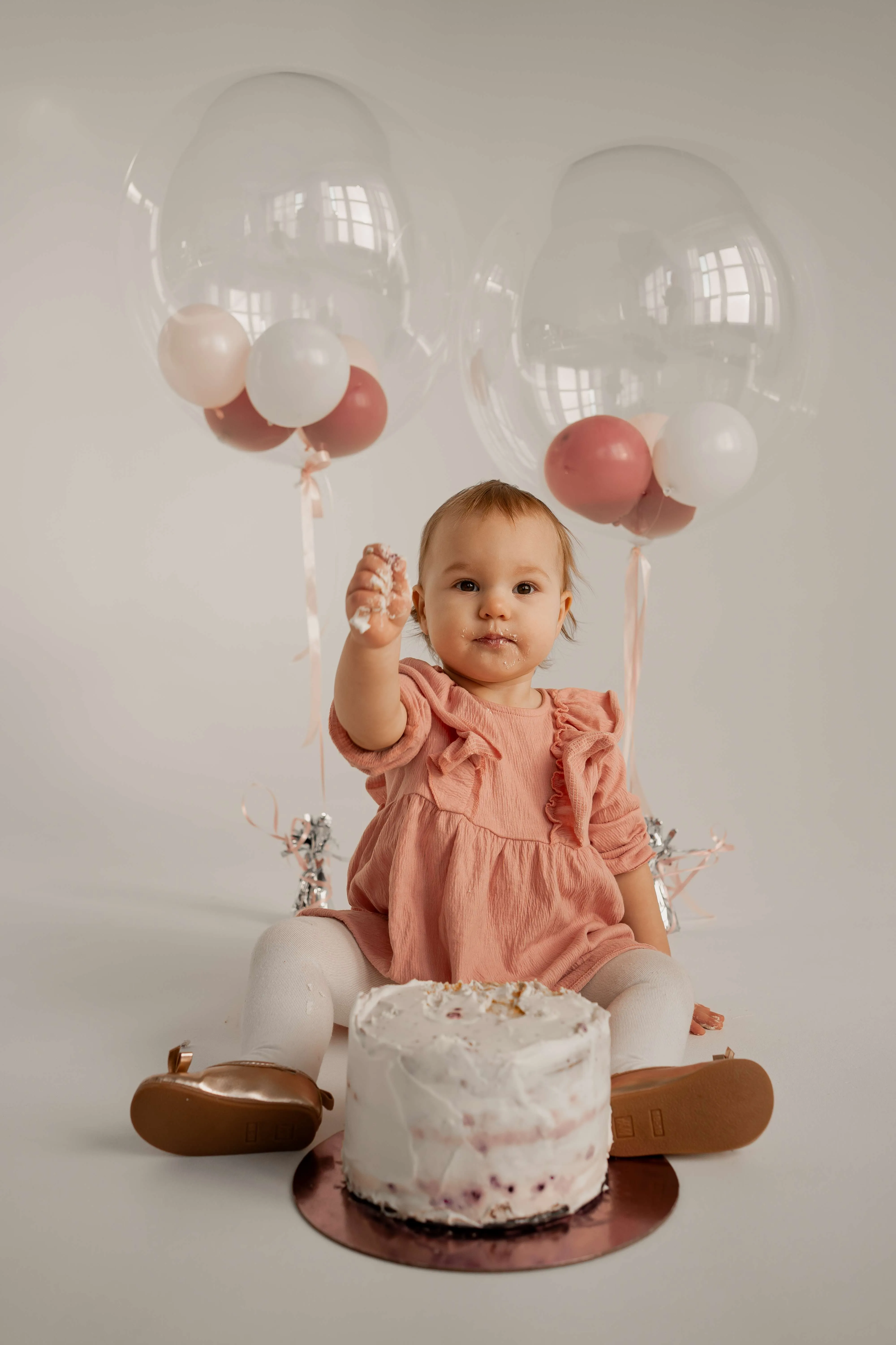 Sesja na roczek w plenerze na Śląsku, uśmiechnięte dziecko podczas zabawy na trawie.